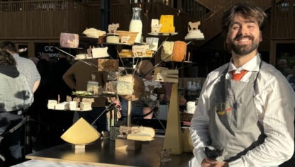 a man smiling at a cheese platter