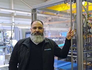 Johnny Pimenta, head of the cheese division at BFR Systems, standing in front of industrial machinery.
