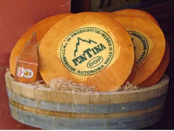 Platter of yellow-paste Fontina cheese with brown rind.