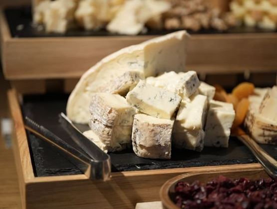 Pieces of blue-veined Gorgonzola cheese on a slate tray.