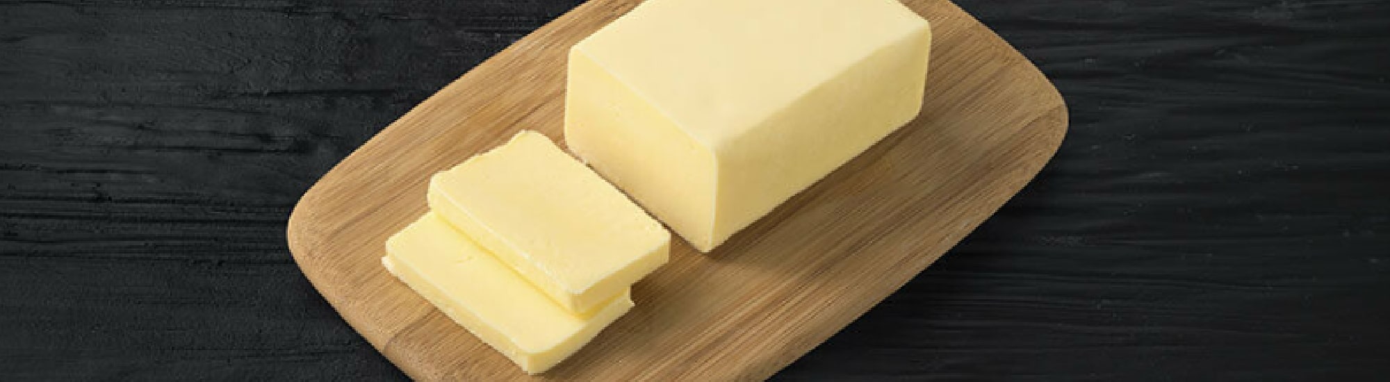 Lump of butter on a wooden tray. 