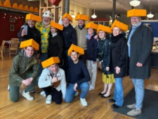 personnes souriantes portants des couvre-chefs en forme de fromage