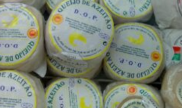 Empilement de fromages portugais Azeitão DOP, emballés individuellement avec une étiquette jaune et bleue.       