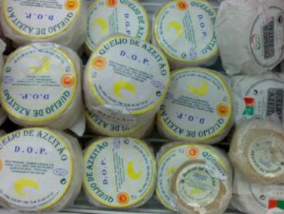 Empilement de fromages portugais Azeitão DOP, emballés individuellement avec une étiquette jaune et bleue.