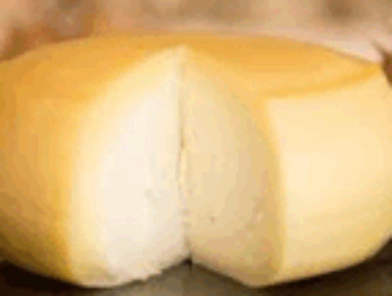 Fromage portugais entier à croûte jaune pâle, entamé pour révéler une pâte blanche ferme et lisse.