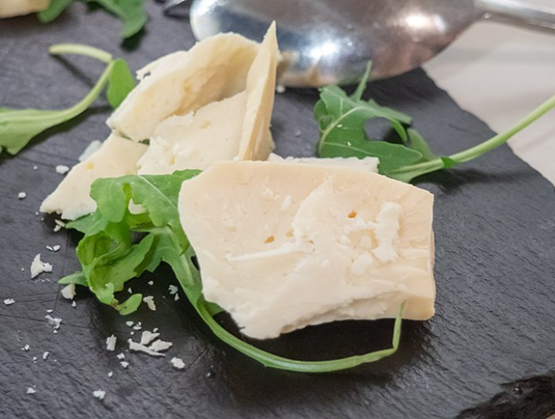 Morceau de fromage crec posé sur une planche en bois sombre