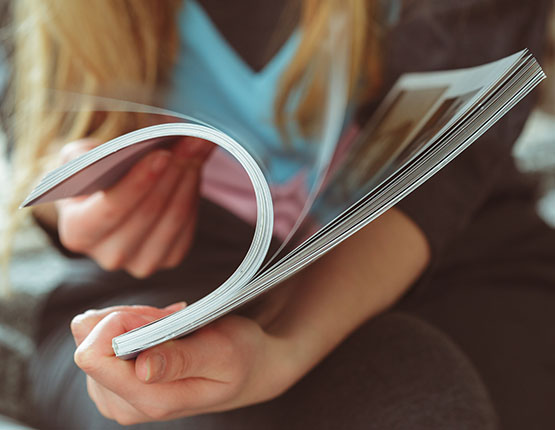 Flipping through a colorful brochure.